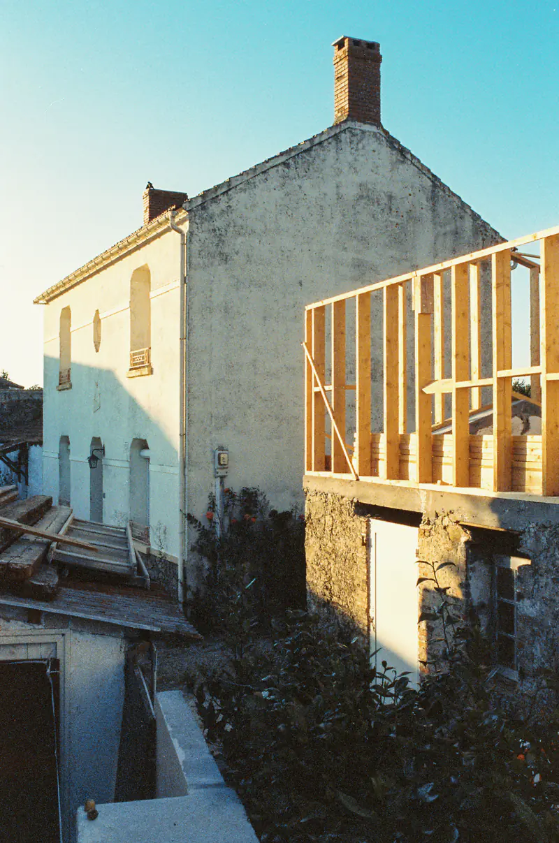 The timber frame of a new addition going up against the wall of an older house