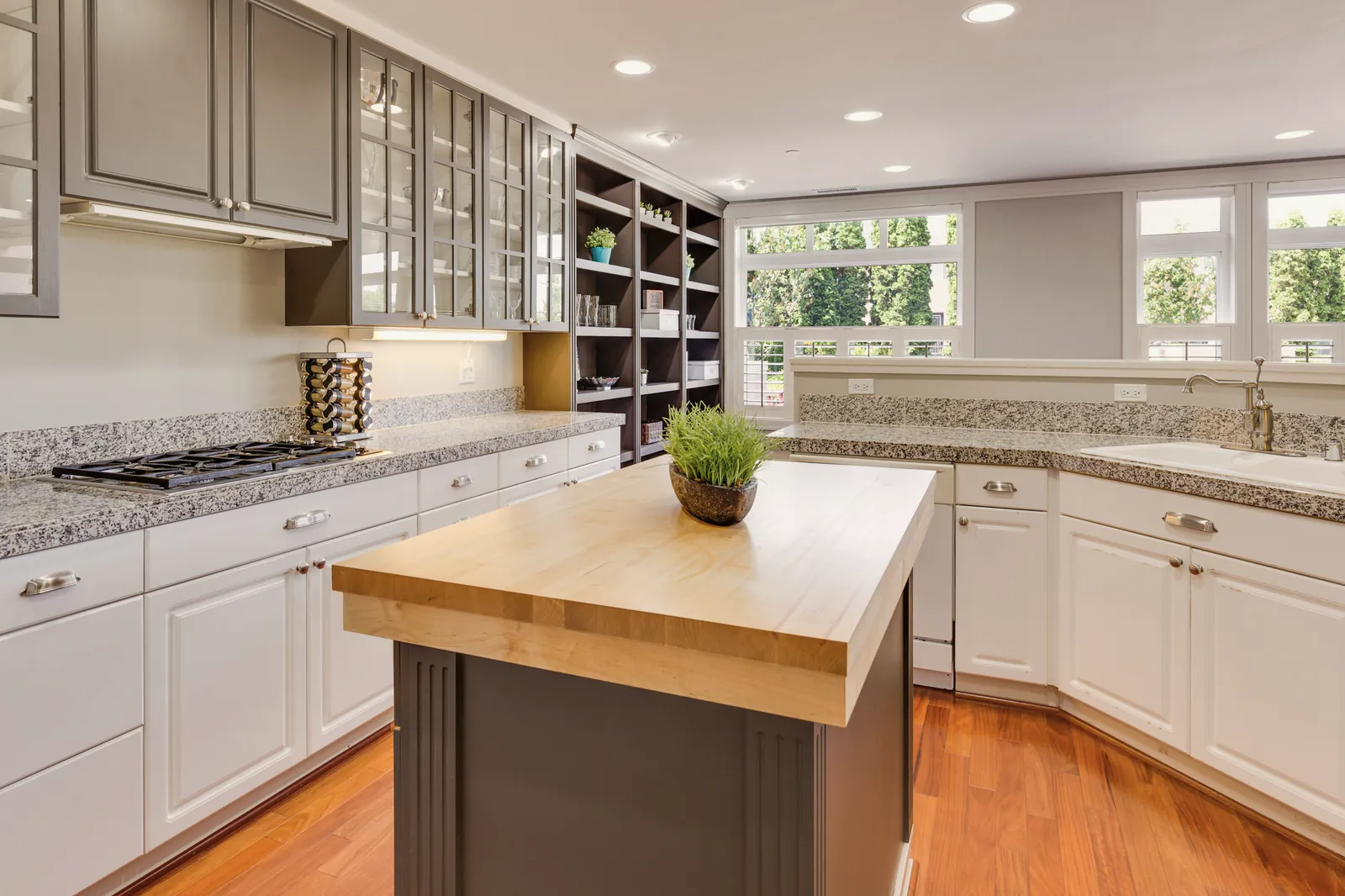 A family kitchen with white cabinets, a butcher-block island and a wood floor