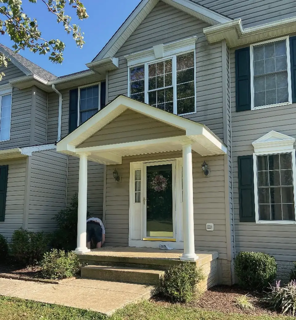 The finished front entry: a gabled portico with white columns over new steps