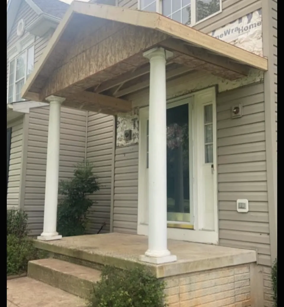 The same front entry during the work, with the new portico roof framed and sheathed over the door